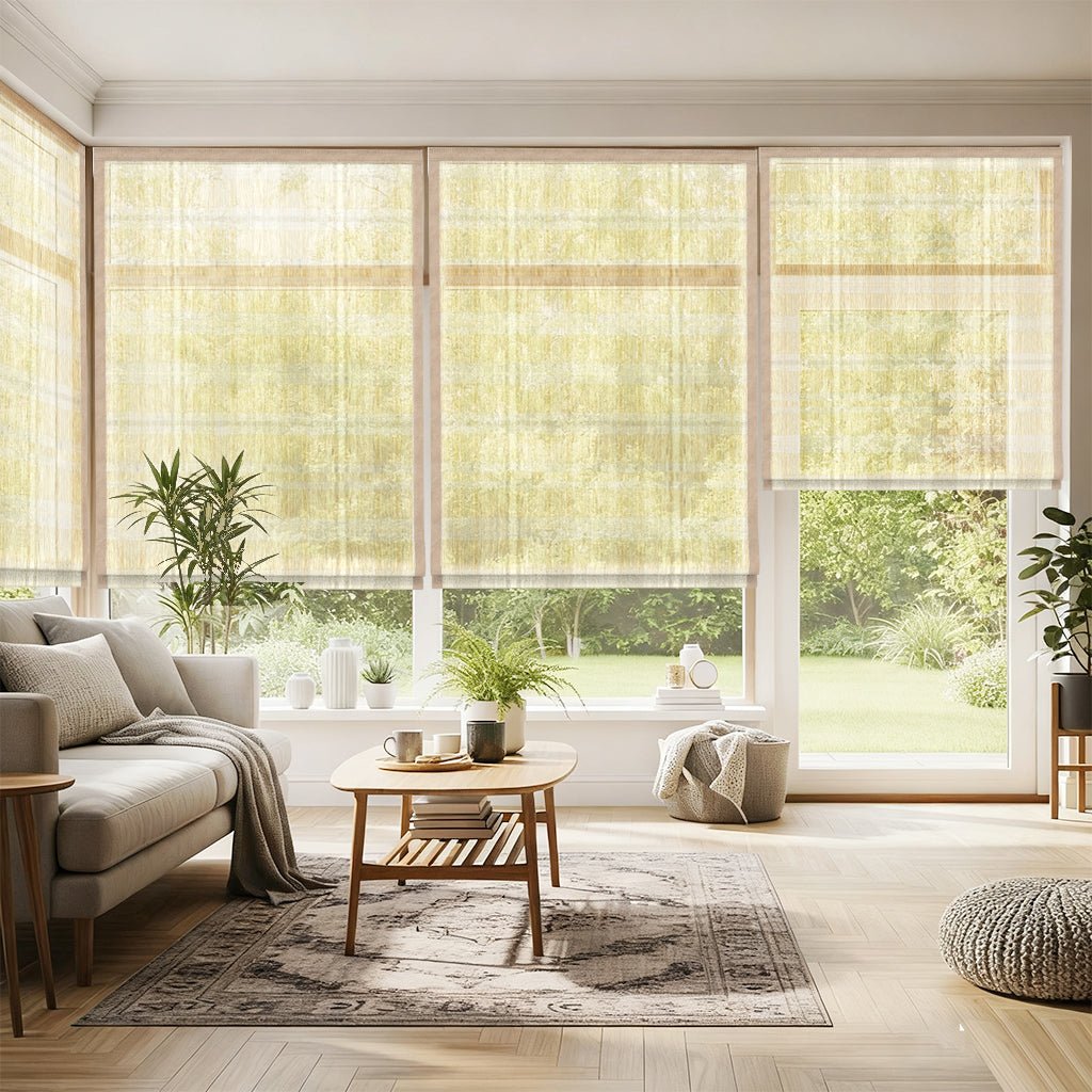 Motorized woven wood shades in bright living room with beige sofa, wooden coffee table, pouf, potted plants, and large windows overlooking green backyard.